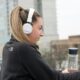 Chica cona uriculares escuchando la radio francesa para aprender francés